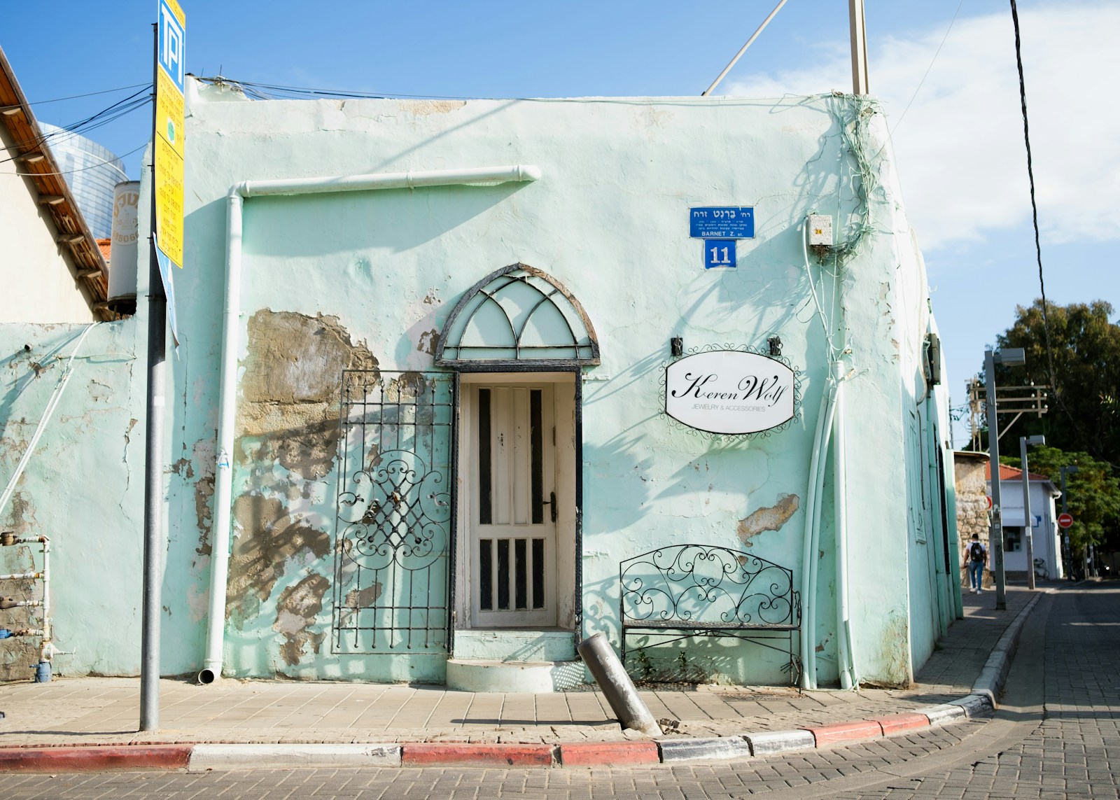 A turquoise historic façade on a street in Neve Tzedek